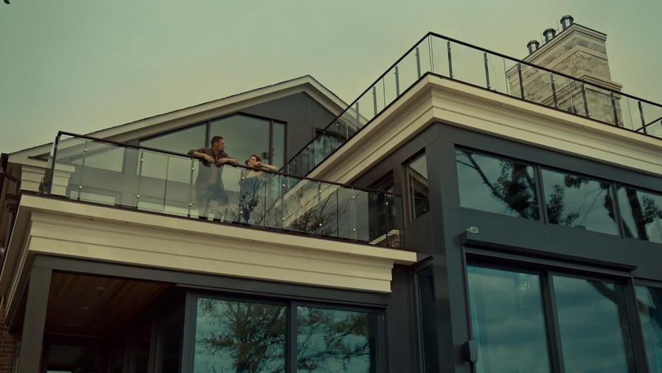 Ben and Mary stand on the balcony sharing a cigarette in the morning.