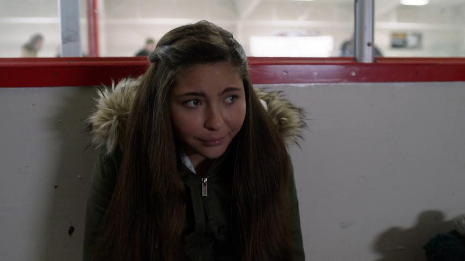 Ruby sits crying by the side of the rink.