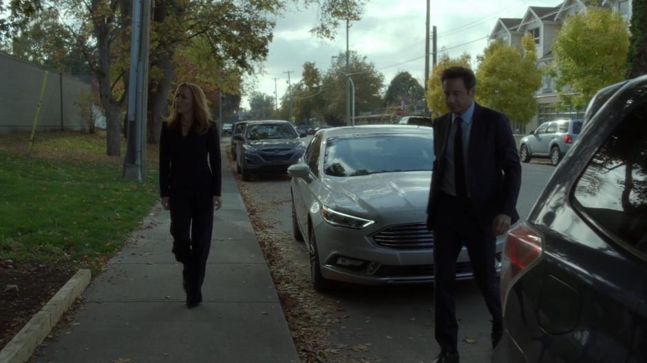 Scully and Mulder get out of their car and walk over to the morgue.