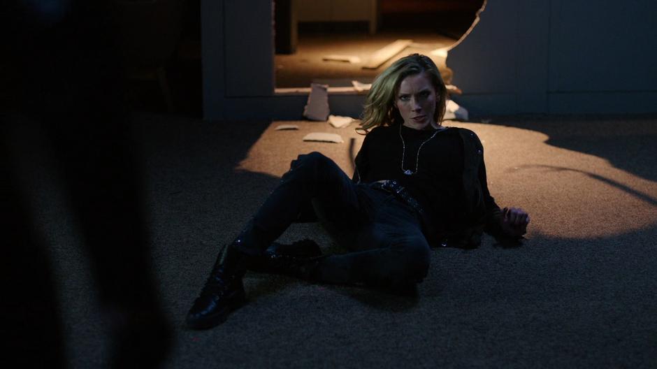 Black Siren looks up from the ground after being thrown down by Dinah.