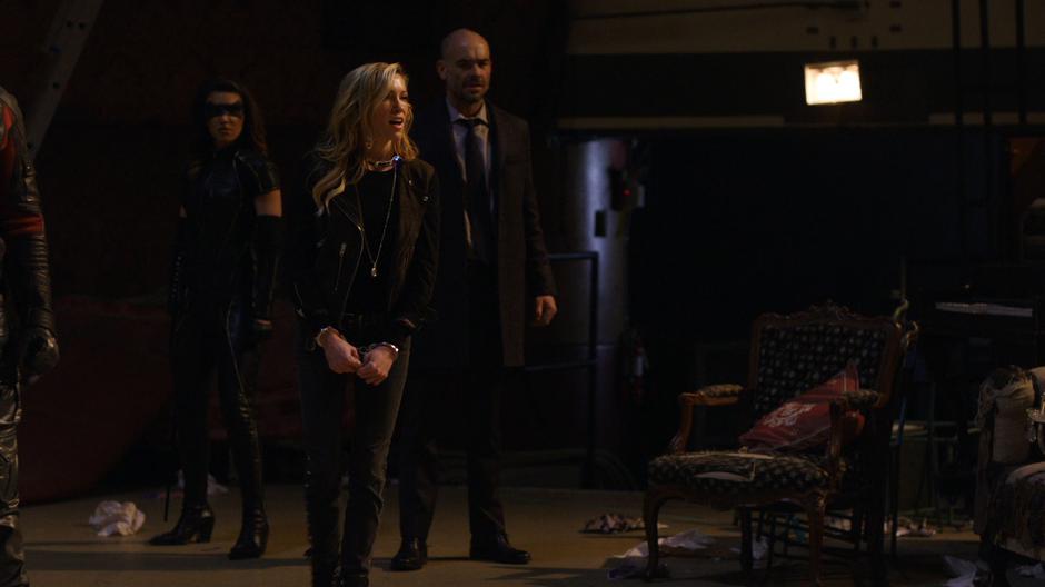 Black Siren walks over to create a distraction while Dinah and Lance watch.