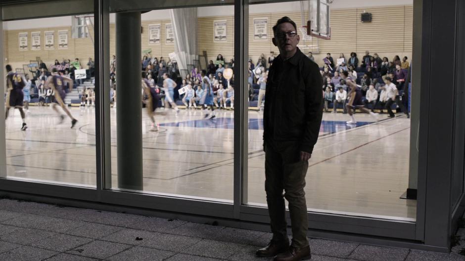 Cayden James looks back from the game going on behind the window as the agents get his attention.