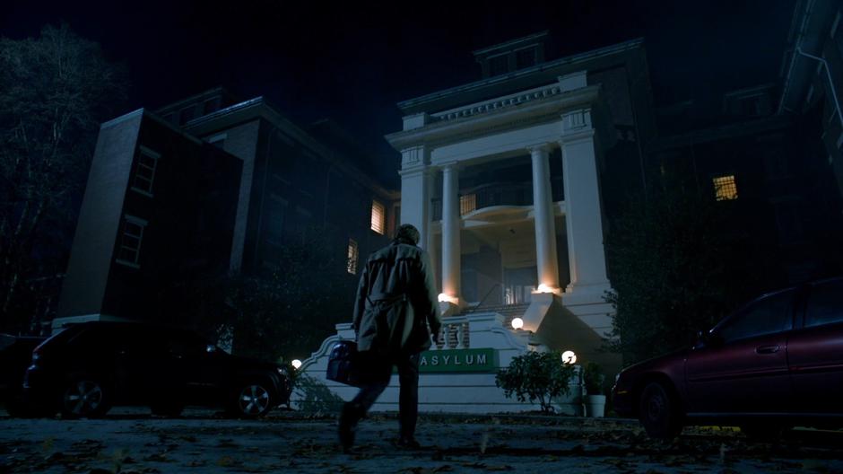 Constantine walks up to the building at night.