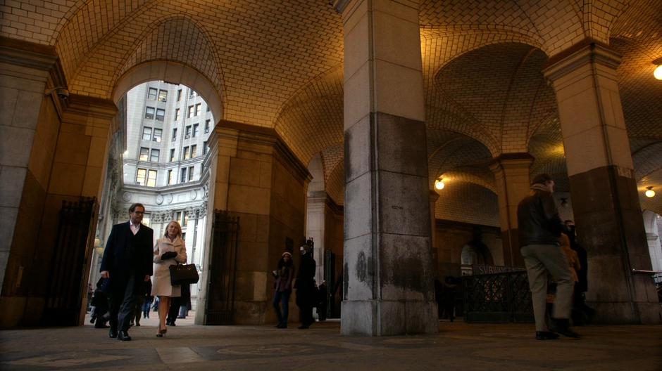 Bull and Abigail Walsh walk under an archway near the courthouse.