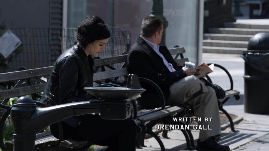 Jane sits on a bench in the park trying to blend in.