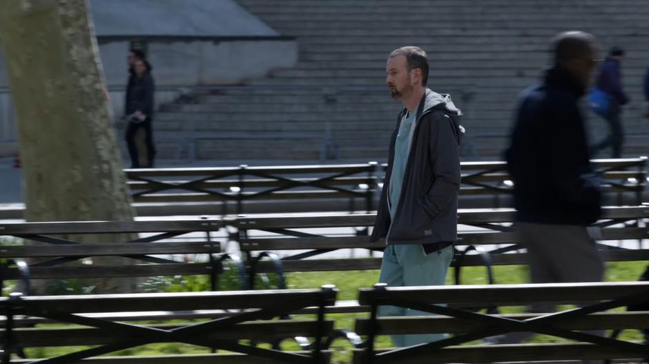 Edward Donella walks into the park wearing his scrubs.