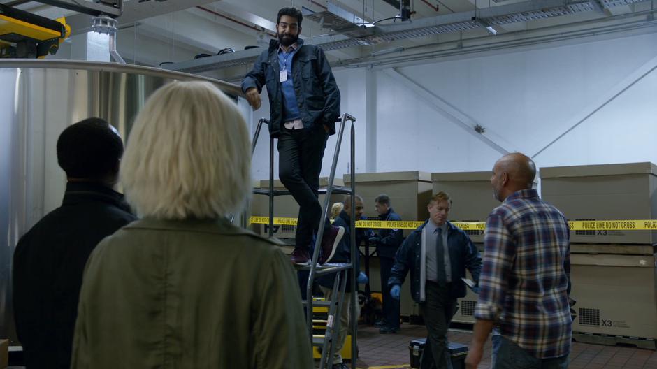 Ravi sarcastically explains the cause of death to Clive and Liv while standing an a ladder next to the grinding vats.