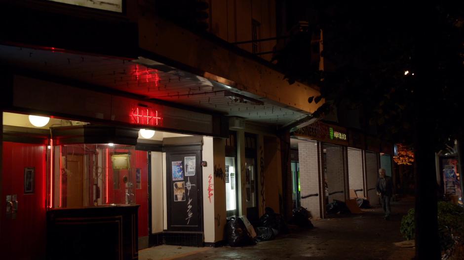 Angus walks down the street to the movie theater turned church.