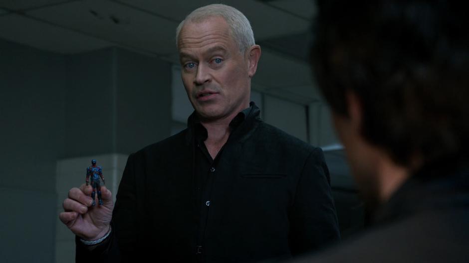 Darhk holds up the tiny version of the A.T.O.M. suit for Ray.
