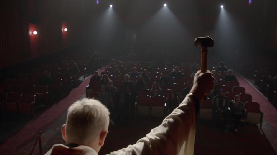 Angus holds the hammer up in front of the crowd.