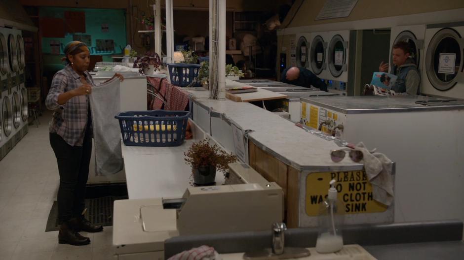 Three people do their laundry inside the store.