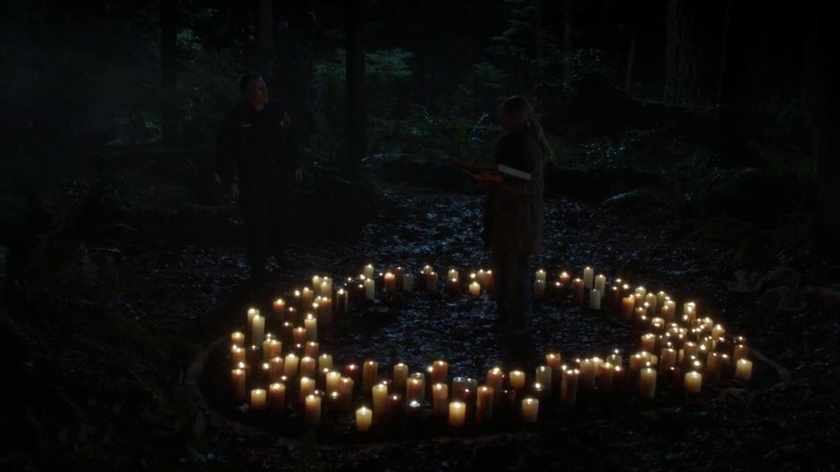 Chief Strong tries to talk to his with Anna while she reads from the grimoire in the circle of candles.