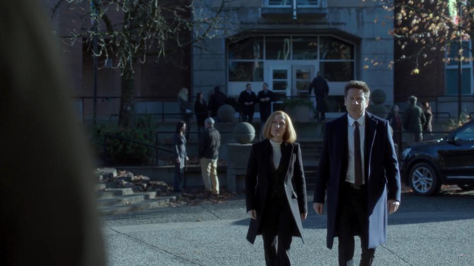 Scully and Mulder walk over to Officer Wentworth.