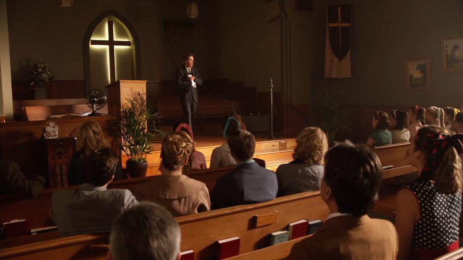 Uncle Lucious preaches at the front of the church.