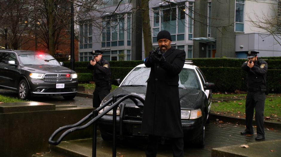 Joe and two other police officers point their guns at Jaco Birch.