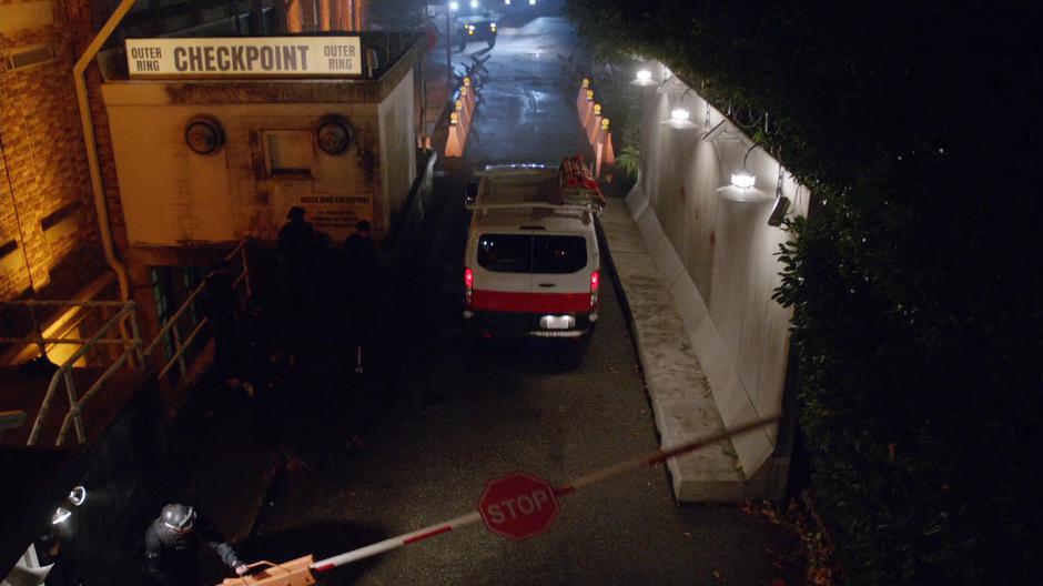 The van drives through the checkpoint into the walled city of Seattle.