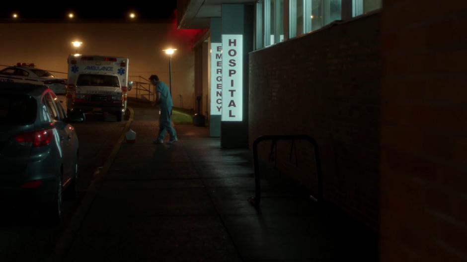 The nurse kneels down over the stranger cooler left outside the emergency room.