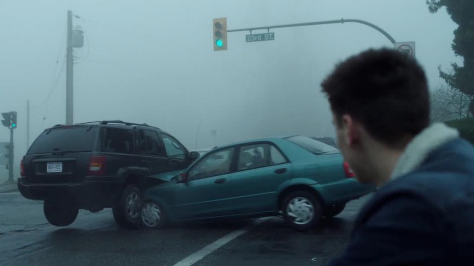 William watches as one car hits another after they both drive through a green light.