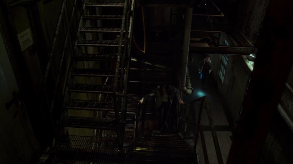 William rushes up the stairs while Mulder runs up from below.