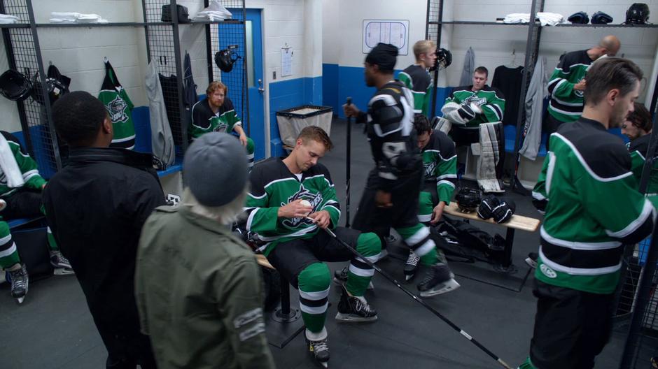 Clive and Liv enter the locker room to interview the players.