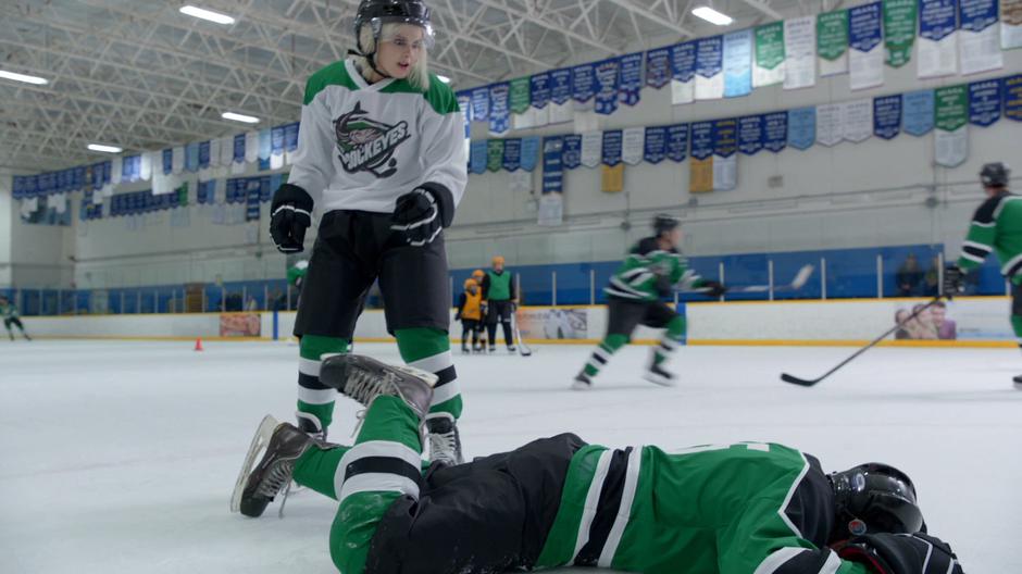 Liv stands over a player after knocking him to the ice.