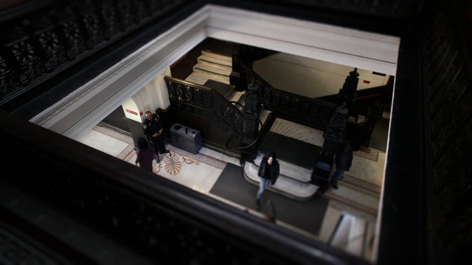 Jessica walks down the stairs and out through the lobby.