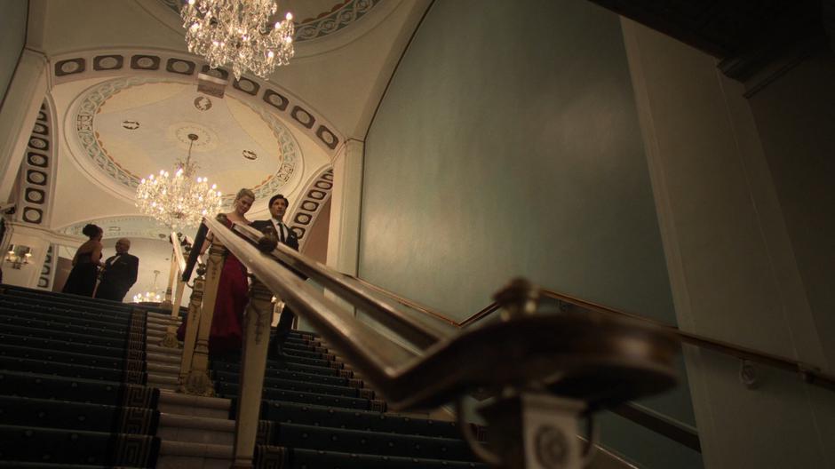 Trish and Griffin walk down the stairs to the exit after the party.