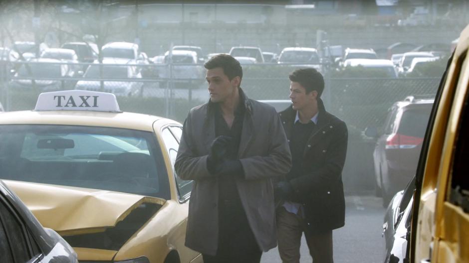 Ralph and Barry weave through destroyed cars heading over to the bus.