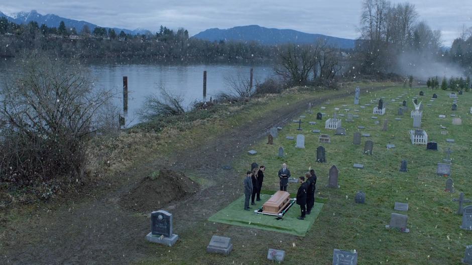 Winn and his friends stand around the coffin during the funeral.