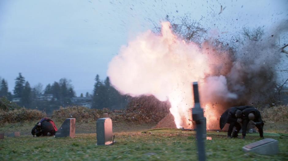 People jump out of the way as the coffin explodes.