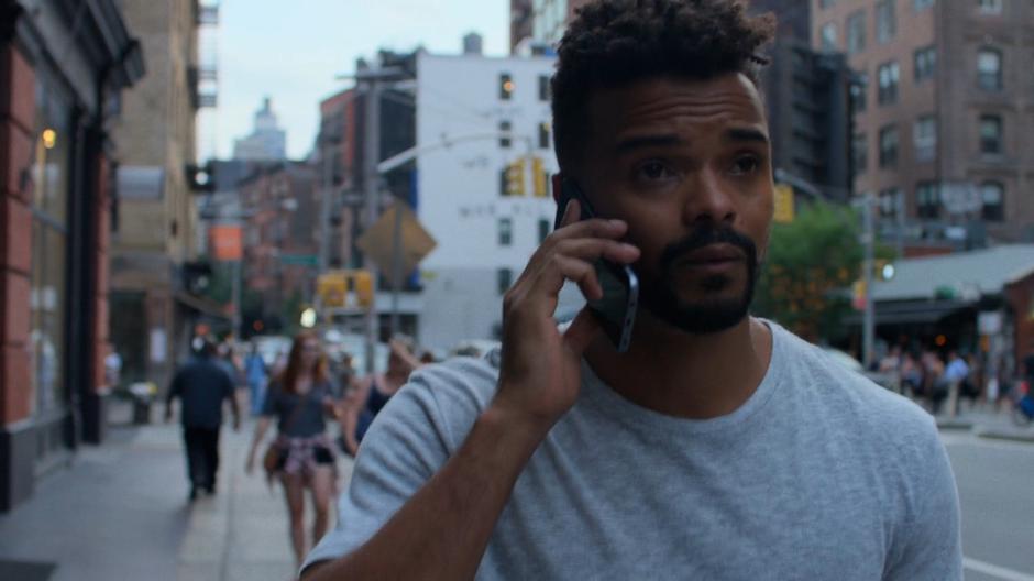 Malcolm talks to Trish on the phone while heading to the bar.