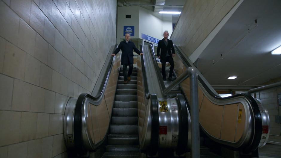 Stacey Boss and Blaine walk down the deactivated escalator to the lockers.