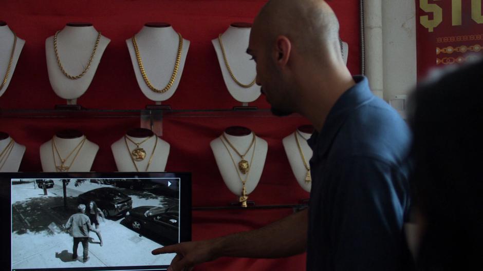 The pawn shop employee shows footage of the doctor and mysterious woman fighting outside.