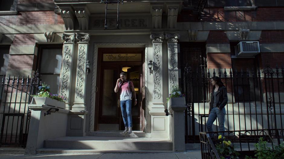 Jessica waits while Eric Ambrose walks out of the building talking on the phone.