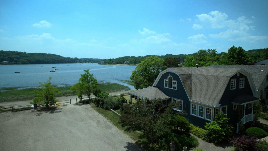 Wide establishing shot of the house next to the water.