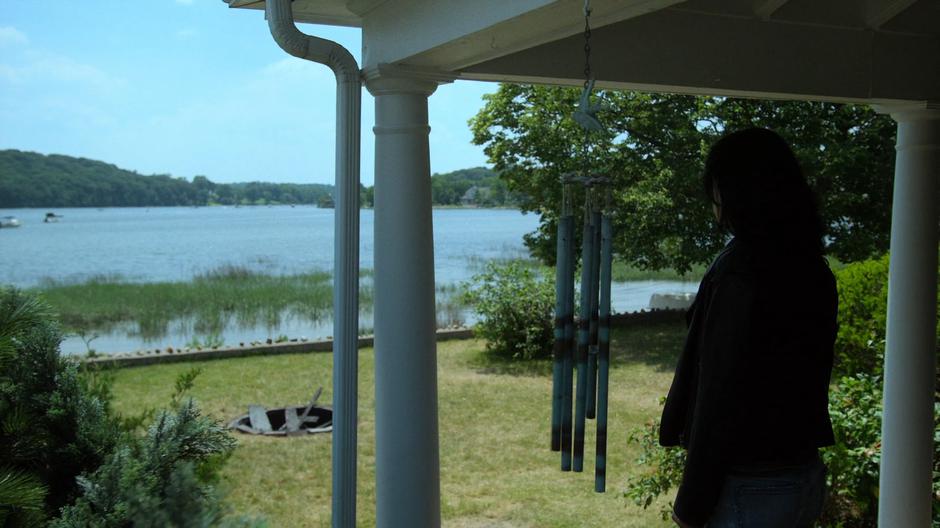 Jessica looks around while standing on the porch.