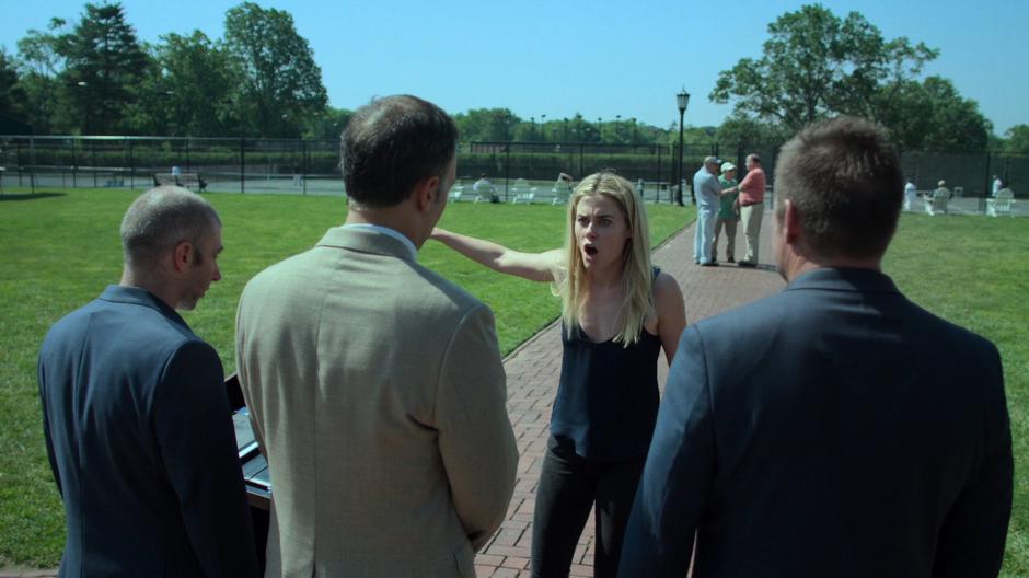 Trish yells at three men out front of the club.