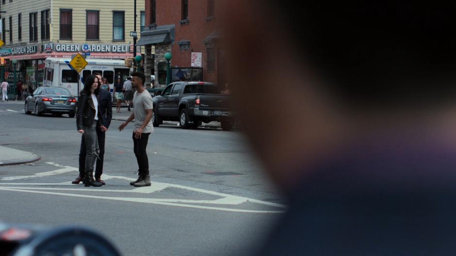 Malcolm tries to talk with Jessica as she stands in the middle of the street looking at the various Kilgraves.