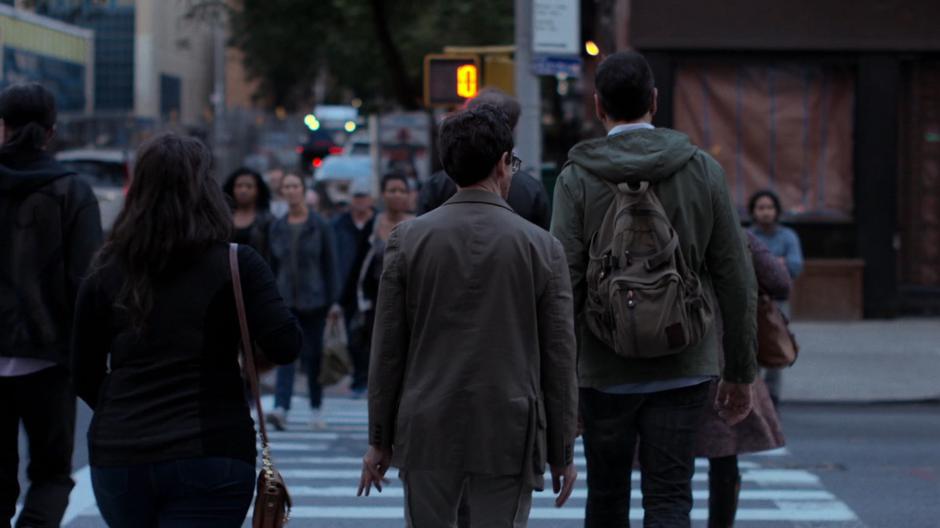 The man Jessica is following crosses the street ahead of her.