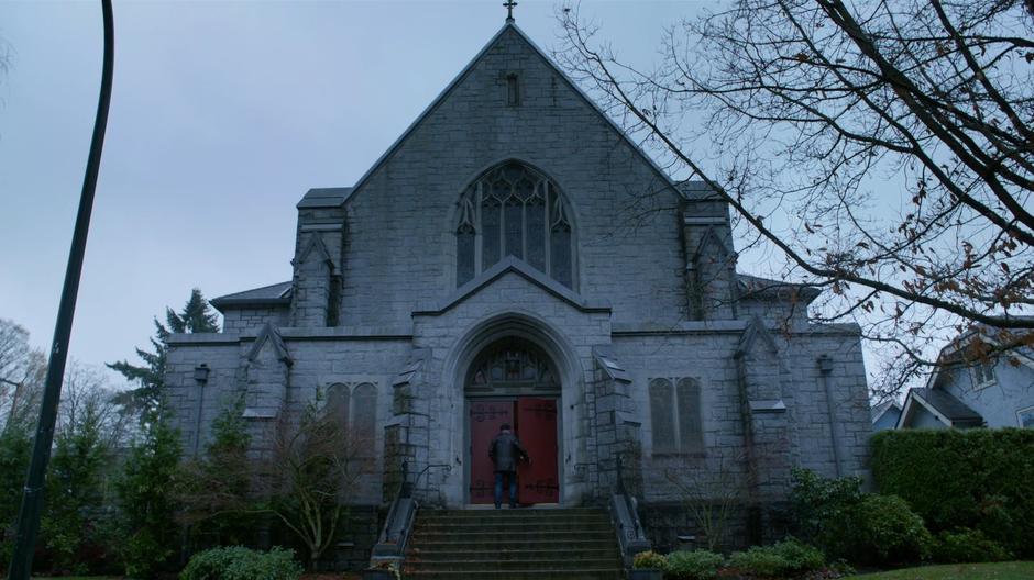 Detective Benedetto walks in through the front door of the church.