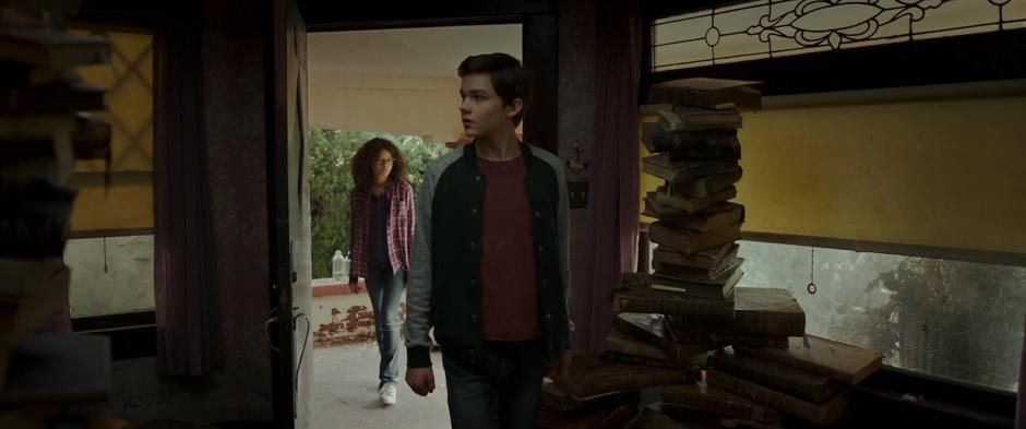 Calvin and Meg look around while walking into Mrs. Who's cluttered home.