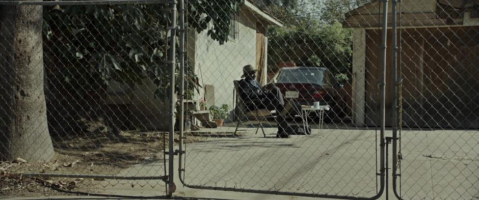 The stranger sits back down and continues to read his newspaper.