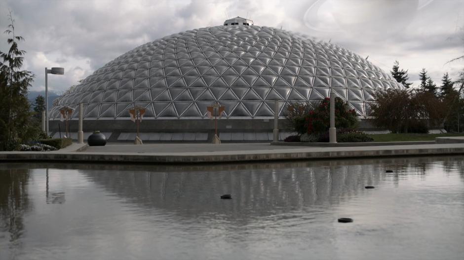 Establishing shot of the dome across a pond.