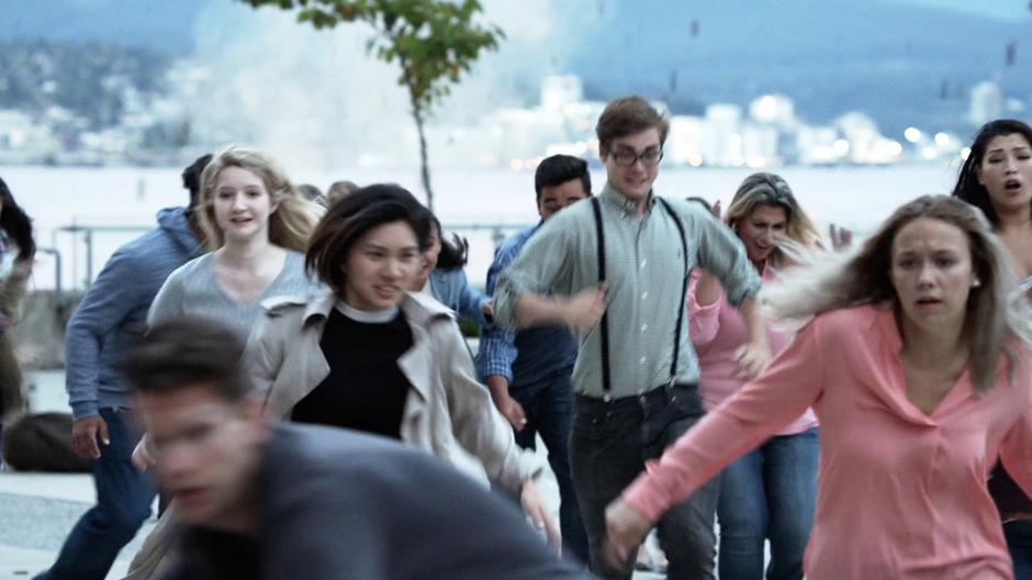 People flee across the plaza as cracks open in the ground.