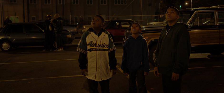 Young Killmonger and his friends watch as the Wakandan aircraft takes off silently.