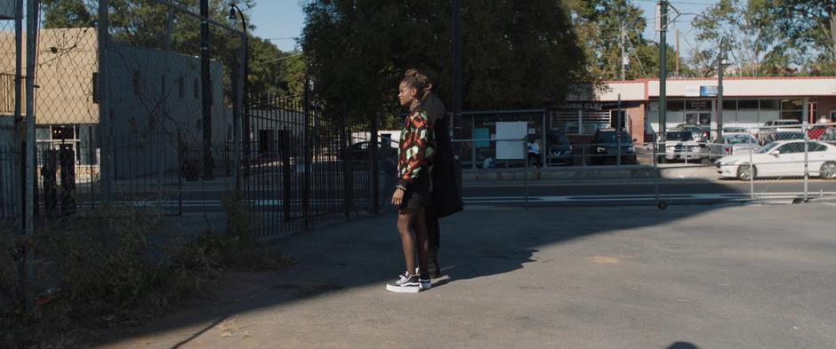 Shuri and T'Challa stand at the fence looking up at the condemned building.