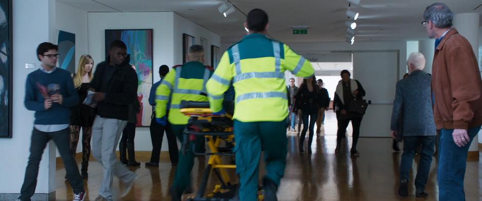 Ulysses Klaue and his goon rush through museum patrons while posing as paramedics.