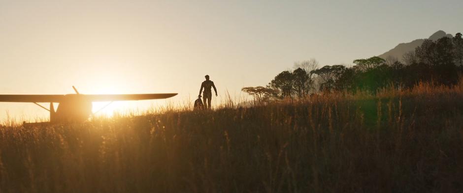 Killmonger drags Ulysses Klaue through the grass from where his plane landed.