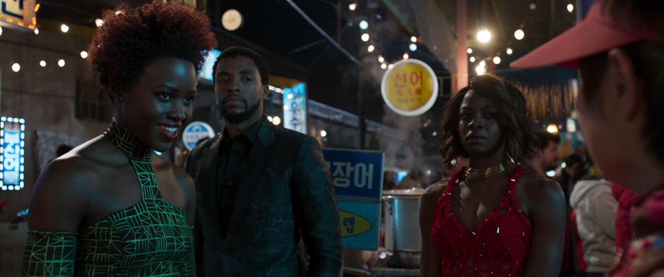 Nakia explains T'Challa & Okoye's presence to her local contact.