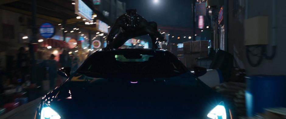 T'Challa rides on top of a car hijacked by Shuri.